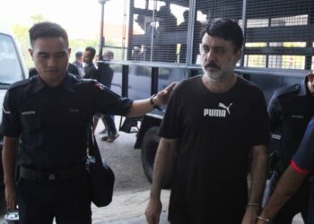 ANGGOTA polis membawa Muhammad Iqbal (dua dari kiri) untuk didakwa atas pertuduhan melakukan amang seksual bukan fizikal terhadap kanak-kanak di Mahkamah Sesyen Kota Bharu, Kelantan. - UTUSAN/ROSALWANI CHE SOH