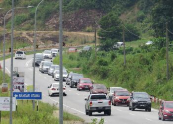 KENDERAAN perantau perlahan ketika melalui kawasan Bandar Utama menghala ke Pusat bandar Gua Musang, Kelantan. - UTUSAN/ AIMUNI TUAN LAH