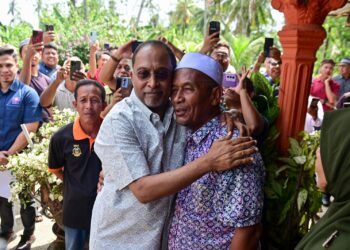 ZAMBRY Abdul Kadir (tengah) memeluk bapa Allahyarham Nurly Sahirah, Azman Mohamad semasa Program Ziarah Kasih KPT UPSI di Kampung Gong Pasir, Kerandang, Jerteh, Besut, Terengganu. -UTUSAN/PUQTRA HAIRRY