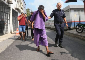 PEMANDU bot (tengah) dibawa keluar dari Mahkamah Majistret Setiu, Besut, Terengganu.