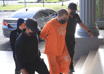 TERTUDUH (tengah) dibawa polis ke Mahkamah Sesyen Pasir Mas, Kelantan. - UTUSAN/ROSALWANI CHE SOH