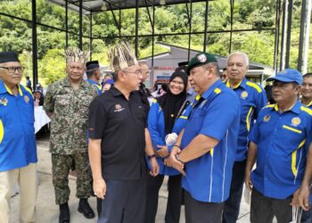 ADLY Zahari (kiri) beramah mesra dengan veteran Angkatan Tentera Malaysia (ATM) semasa Program Peduli Veteran Madani di Sekolah Kebangsaan Sungai Rual, Jeli, Kelantan.  -UTUSAN/ROHANA ISMAIL