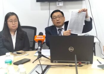 NG Kian Nam (kanan) menunjukkan notis tuntutan saman oleh keluarga dua pelancong warga China yang maut dihempap pokok tahun lalu di George Town, Pulau Pinang, dalam sidang akhbar sebelum ini.