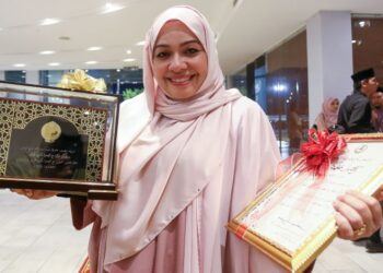 SHARIFAH Khasif Fadzillah Syed Badiuzzaman menunjukkan Anugerah Tokoh Maal Hijrah Negeri Perak diterimanya pada Majlis Sambutan Maal Hijrah 1447H peringkat negeri di Ipoh semalam. - UTUSAN/MUHAMAD NAZREEN SYAH MUSTHAFA