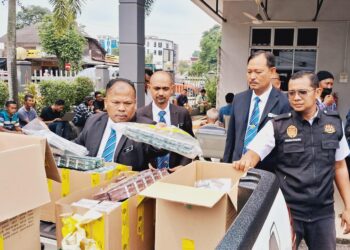 PEGAWAI dan anggota kesihatan memeriksa paket rokok di Mahkamah Majistret Kemaman di Terengganu. - UTUSAN/NIK NUR IZZATUL HAZWANI NIK ADNAN
