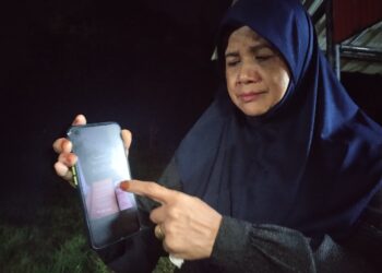 RUSLINAN Abd. Razak menunjukkan pesanan menerusi aplikasi WhatsApp  yang dihantar Muhammad Adib Hazim ketika ditemui di Tanah Perkuburan Islam Kampung Pasir Badak, Hulu Besut, Terengganu. - UTUSAN / WAN ZURATIKAH IFFAH WAN ZULKIFLI