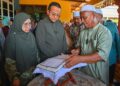 AHMAD Samsuri Mokhtar (dua dari kiri) melihat naskhah al-Quran tulisan tangan pelajar Universiti Pendidikan Sultan Idris (UPSI), Nurly Shahirah Azman, yang maut dalam kemalangan di Jalan Raya Timur-Barat (JRTB) berhampiran Tasik Banding, Gerik, 9 Jun lalu, di rumah arwah di Kampung Gong Pasir, Kerandang, Jertih, Besut, Terengganu. - UTUSAN/PUQTRA HAIRRY