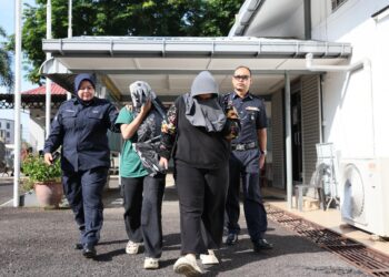 TERTUDUH (dua dari kiri) yang didakwa mendera anak perempuan sepupunya dibawa keluar dari Mahkamah Sesyen Kemaman, Terengganu. -UTUSAN/NIK NUR IZZATUL HAZWANI NIK ADNAN