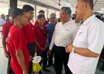 HIRUDIN Mohot (kanan) beramah mesra dengan pelajar yang menyertai Kempen Kesedaran Keselamatan anjuran HPB di SMK Cherang Ruku, Pasir Puteh, Kelantan. - UTUSAN/TOREK SULONG
