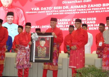 PEMANGKU Ketua UMNO Bahagian Bentong, Datuk Seri Mohd Zaini Salleh menyampaikan cenderahati kepada Ahmad Zahid Hamidi semasa Mesyuarat Perwakilan UMNO Bahagian Bentong di Pahang, hari ini. - UTUSAN/ SALEHUDIN MAT RASAD