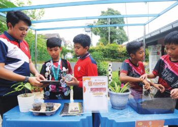 BEBERAPA
orang murid dibimbing  oleh guru cara  membuat baja daripada  hampas kopi untuk tanaman sayuran sekolah di SK Bukit Indah, Johor Bahru. – UTUSAN/
RAJA JAAFAR ALI