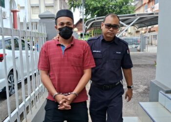 MOHD. Norzaizhul Zainudin diiring polis keluar dari Mahkamah Majistret Kemaman, Terengganu. - UTUSAN/NIK NUR IZZATUL HAZWANI NIK ADNAN