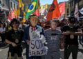 PENUNJUK perasaan memakai topeng menyerupai wajah Donald Trump dan Jair Bolsonaro dalam demonstrasi membantah tarif yang dikenakan AS terhadap Brazil di Sao Paulo, baru-baru ini. - AFP