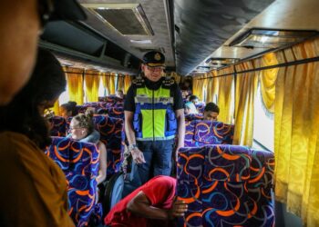 STIEN Van Lutam melakukan pemeriksaan terhadap sebuah bas ekspres ketika operasi di Plaza Tol Alor Setar Utara, Alor Setar, Kedah.-UTUSAN/ SHAHIR NOORDIN