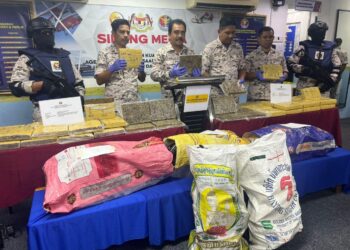 ROMLI Mustafa (tiga dari kiri) menunjukkan ketulan mampat dipercayai ganja yang dirampas menerusi pemeriksaan sebuah bot kayu di kedudukan 0.3 batu nautika dari barat Pulau Ketam dalam sidang akhbar di Kuala Perlis hari ini.-UTUSAN/ASYRAF MUHAMMAD