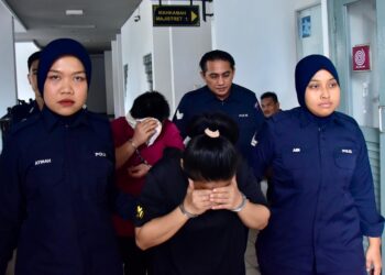 EASTA Masa Pengala (baju hitam) dan Manuel Pangawat dihadapkan ke Mahkamah Sesyen, Ayer Keroh, Melaka atas pertuduhan menganiaya anak perempuan sehingga maut. - UTUSAN/ARIF HAMIZAN MISKON