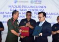 KETUA Menteri Melaka, Datuk Seri Ab. Rauf Yusoh (tengah) menyaksikan penyerahan dokumen antara Arman Rumaizi Ahmad (kiri) dan Ketua Pegawai Eksekutif IATAC, Kapten Kenneth Yap pada Majlis Peluncuran dan Hari Terbuka Program Sarjana Muda Penerbangan 2u1i di Batu Berendam, Melaka. - UTUSAN/ARIF HAMIZAN MISKON