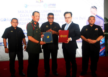 KETUA Menteri Melaka, Datuk Seri Ab. Rauf Yusoh (tengah) menyaksikan penyerahan dokumen antara Arman Rumaizi Ahmad (kiri) dan Ketua Pegawai Eksekutif IATAC, Kapten Kenneth Yap pada Majlis Peluncuran dan Hari Terbuka Program Sarjana Muda Penerbangan 2u1i di Batu Berendam, Melaka. - UTUSAN/AMRAN MULUP