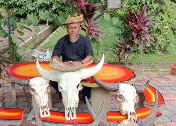Rozali Abd. Rani atau lebih dikenali sebagai Pak Wea menunjukkan tetuang dan hiasan tengkorak kerbau bertanduk hasil karyanya.