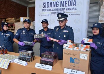MUHAMMAD Ilyas Queek Abdullah (dua dari kanan) menunjukkan barang rampasan penyeludupan rokok dan minuman keras hasil serbuan dijalankan di beberapa premis sekitar Klang dan Rawang, Selangor sepanjang bulan Mei lalu.-GAMBAR/ IHSAN JKDM