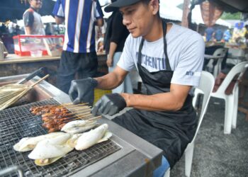 SEORANG peniaga menyediakan makanan unik berasaskan mentarang iaitu sate mentarang bersempena Pesta Makanan Tradisional Perlis (MANTAPs) di Taman Buah-Buahan Eksotik, Sungai Batu Pahat di Kangar, Perlis semalam.-UTUSAN/IZLIZAN OTHMAN