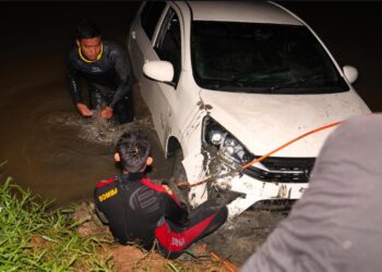 KERETA yang dipandu Ija Nizaruddin dibawa naik oleh pasukan bomba dari sungai di Kampung Tui, Bukit Kepong, Muar.
