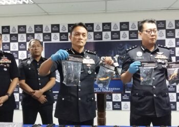 DZULKHAIRI Mukhtar (dua dari kanan) menunjukkan pistol tiruan yang dirampas dalam sidang akhbar di IPD Melaka Tengah di Batu Berendam, Melaka. - UTUSAN/MUHAMMAD SHAHIZAM TAZALI