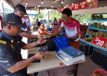 PEGAWAI dan anggota penguat kuasa KPDN mengeluarkan kompaun ke atas peniaga durian yang didapati masih menggunakan alat penimbang tamat tempoh dikompaun ketika pemeriksaan di sebuah gerai menjual buah-buahan di Sendayan-Gadung, Seremban hari ini. - UTUSAN/MOHD SHAHJEHAN MAAMIN