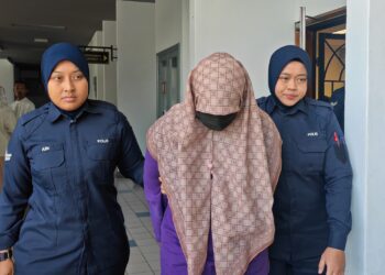 PENGASUH taska dibawa anggota polis selepas selesai prosiding reman bagi membantu siasatan kes kematian bayi enam bulan di sebuah taska di Padang Temu, Melaka. - UTUSAN/AMRAN ALI