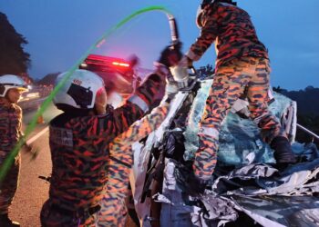 ANGGOTA bomba membawa keluar dua mangsa yang tersepit dalam kemalangan di Kilometer 253, Lebuh Raya Utara-Selatan arah selatan dekat Kuala Kangsar hari ini. - UTUSAN/IHSAN JBPM