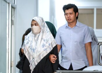 ISMANIRA Abdul Manaf (kiri) bersama suaminya Zaim Ikhwan tiba di Kompleks Mahkamah Petaling Jaya semalam.-UTUSAN/FARIZ RUSADIO