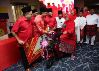 ASYRAF Wajdi Dusuki (dua dari kiri) dan Fathul Bari Mat Jahya ketika menyampaikan hadiah cabutan bertuah kepada salah seorang penerima pada Majlis Perasmian Serentak Mesyuarat Perwakilan Wanita, Pemuda dan Puteri UMNO Bahagian Kangar di Hotel Putra Regency, Kangar, Perlis hari ini. -UTUSAN/ASYRAF MUHAMMAD