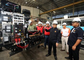 AEDY FADLY Ramli meninjau proses pembuatan bas di Telok Gong, Pelabuhan Klang, Selangor, hari ini.-UTUSAN/ISKANDAR SHAH MOHAMED