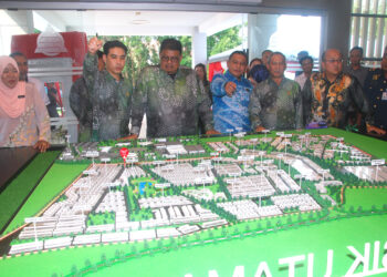 AB. Rauf Yusoh melihat reka bentuk projek yang akan dibangunkan selepas merasmikan pelancaran Pejabat Jualan MTD Properties di Taman Tasik Utama, Ayer Keroh, Melaka hari ini.- UTUSAN/AMRAN MULUP