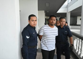 MOHD. Salihudin Hasan diiringi anggota polis selepas didakwa di Mahkamah Majistret Ayer Keroh, Melaka hari ini atas pertuduhan mencederakan bapanya minggu lalu.-UTUSAN /AMRAN ALI.
