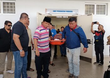 JENAZAH salah seorang mangsa dibawa keluar dari Unit Forensik Hospital Rembau untuk urusan pengebumian.-UTUSAN/NOR AINNA HAMZAH