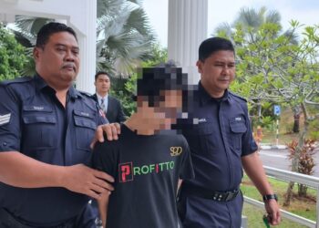 TERTUDUH diiringi anggota polis ketika dihadapkan ke Mahkamah Sesyen, Alor Gajah, Melaka atas pertuduhan mencabul dua anak perempuan tiri. - UTUSAN/MUHAMMAD SHAHIZAM TAZALI