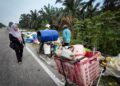 SITI Mastura Mohd. Salleh meninjau lokasi pembuangan sampah di tepi jalan utama di Kampung  Simpang Empat, Hutan Melintang, Bagan Datuk. – UTUSAN/AIN SAFRE BIDIN