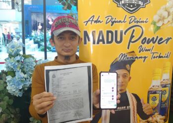 MAZLI Hamzah menunjukkan laporan polis yang dibuat selepas kerugian lebih RM100,000 akibat terpedaya dengan peluang perniagaan lembu korban di Thailand oleh seorang individu mendakwa bergelar Datuk.