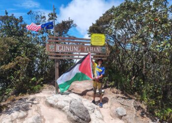 TAJUDDIN Mat Amin mengibarkan bendera Palestin bersama Jalur Gemilang kerana simpati dengan nasib penduduk Gaza di puncak Gunung Tahan, Taman Negara Kuala Tahan di Jerantut, Pahang.