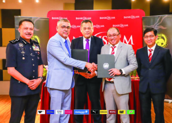 MIZAN (dua dari kanan) bertukar dokumen dengan Noor Azman selepas  menandatangani perjanjian antara Bank Islam dan FAM, semalam.-IHSAN FAM