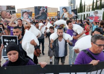 AKTIVIS Israel berarak sambil membawa guni tepung menuju ke ibu pejabat Kementerian pertahanan Israel di Tel Aviv bagi membantah krisis kebuluran dan pemindahan paksa penduduk Palestin di Semenanjung Gaza.-AFP