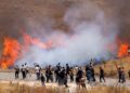 KOMUNITI Druze Syria berjalan merentasi asap gas pemedih mata yang dilepaskan tentera Israel ketika cuba menyeberangi pagar dawai berduri ke Bukit Golan berhampiran Majdal Shams. – AFP