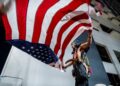 SEORANG lelaki membawa bendera AS semasa perhimpunan kebangsaan ‘No Kings’ bagi membantah pentadbiran Donald Trump di bandar Austin, Texas, pada 14 Jun lepas. – AFP