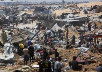 PENDUDUK Palestin memeriksa kemusnahan di kem perlindungan sementara susulan serangan kereta kebal Israel di Khan Younis, selatan Gaza, pada 11 Julai lalu. – AFP