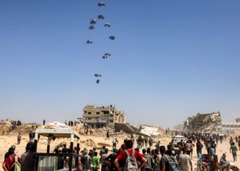 ORANG ramai berkumpul ketika pesawat pengangkut tentera C-130 Hercules menjatuhkan bantuan kemanusiaan di utara Gaza, kelmarin. – AFP