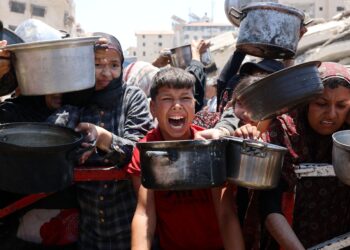 PENDUDUK Palestin berkumpul di pusat agihan sup kacang dal di Bandar Gaza, utara wilayah, kelmarin.- AFP