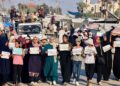 WANITA dan kanak-kanak memegang plakad ketika menyertai perarakan senyap membantah perang dan kebuluran di kawasan Al-Mawasi, timur Khan Younis, di selatan Semenanjung Gaza.-AFP
