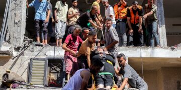 ORANG ramai membantu pasukan kecemasan menurunkan seorang wanita yang cedera selepas sebuah bangunan musnah dibedil tentera Israel di tengah Semenanjung Gaza, Palestin.– AFP