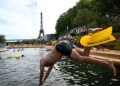 SEORANG perenang terjun ke dalam air di kawasan Grenelle di Sungai Seine berhampiran Menara Eiffel di Paris, Perancis.-AFP